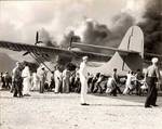 Air Station personnel move a damaged PBY Catalina away from burning hangars at Kaneohe Naval Air Station, Oahu, Hawaii, Dec 7, 1941.