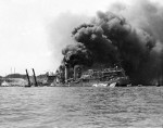 USS Shaw burning in partially sunk Floating Drydock YFD-2, Pearl Harbor, Oahu, Hawaii, Dec 7, 1941. Note men at left playing fire hoses in the direction of the drydock.