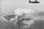 B-24 Liberator of the US 307th Bomb Group over the smoking airstrip on Nauru Island after being bombed, Apr 20, 1943.