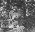 TSgt3 Donald B. Calamar field-cleans a magazine spring of an M-3 Submachine gun. Europe, circa 1944.