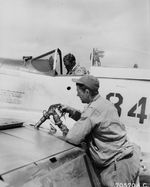 USAAF Capt Arthur Bridge sitting in the cockpit of his P-51D Mustang as his crew chief, Sgt JM Thompson, gasses the plane, Iwo Jima, Mar 10, 1945. Note Colt 1911A sidearm in front of the windscreen.