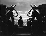 Sailor standing watch at a 40mm Bofors gun mount aboard USS Hornet (Essex-class), 1944