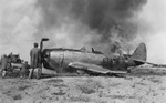 Damage crews dousing the flames after a P-47N Thunderbolt of the 413th Fighter Squadron belly-landed at Central Field, Iwo Jima, Japan, 7 Sep 1945.