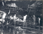 Damage control parties trying to bring fires under control on the hangar deck of USS Intrepid following the crash of a Japanese special attack aircraft off the Philippines, 25 Nov 1944 