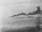 The USS Bunker Hill, burning from two special attack aircraft crashing through the flight deck off Okinawa, 11 May 1945. Note cruiser Wilkes-Barre at extreme left and carrier Randolph at right.