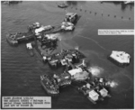 Overhead view of the progress of the salvage work on the sunken battleship USS Arizona in Pearl Harbor, Hawaii, 21 Mar 1943, a year and a half after the attack. Note flag flying from staff amidships.