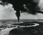 Strike photo from USS Ticonderoga aircraft showing burning oil storage tanks on the banks of the Mekong River in Saigon, French Indochina (Ho Chi Minh City, Vietnam), 12 Jan 1945.