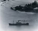 Japanese freighters Shoei Maru beached and burning and Takebe Maru damaged and trailing oil on the coast of French Indochina (Vietnam) north of Qui Nhon after being attacked by 175 USN carrier planes, 12 Jan 1945.