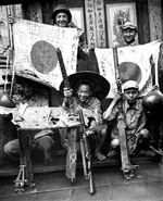 US soldier, Chinese soldier, and Chinese guerrilla fighters displaying captured Japanese flags, Browning machine guns, and MP 34 submachine gun, China, 1940s