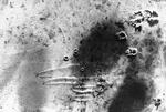 Overhead view of a South African Air Force raid on the German airfield at Martuba, Libya, 6 Jul 1942. Note circular dust patterns of bomb bursts and lines of dust kicked up by scrambling aircraft.