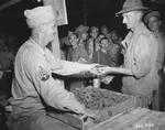 James Mills serving a doughnut to Dean Hodge at the headquarters of Allied Northern Combat Area Command, Shadazup, Burma, 22 Jul 1944