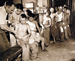 Lieutenant F. A. Reilly of US Navy Medical Corps treating Japanese prisoners of war, Guam, Aug-Sep 1945