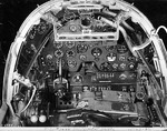 Close-up view of a P-38G Lightning aircraft cockpit, 23 Dec 1942; note the yoke rather than stick control and the bullet proof glass panel above the instrument panel. Photo 2 of 3.