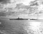Silhouette of the battleship USS New Jersey with a destroyer coming alongside, probably for refueling, Pacific Ocean, late 1944 or early 1945.