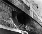 Torpedo damage to the battleship USS California sustained in the Attack on Pearl Harbor 7 Dec 1941 and photographed in the Pearl Harbor drydock, Apr 1942. Note armor belt above the hole.