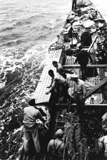 US Navy salvage team removes a damaged torpedo from its stowage position on the deck of the Captured German submarine U-505 before jettisoning the torpedo over the side, eastern Atlantic, 9 June 1944.