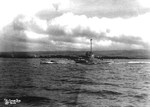 US Submarine R-14 underway in the Main Channel at Pearl Harbor, Hawaii, mid-1930s. Note the Ford Island fuel tanks in the background.