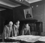 Wei Lihuang and others studying a field map, China, late 1940s