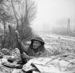 A soldier of 1st Battalion, Rifle Brigade, UK 7th Armored Division firing a 2-inch mortar, northwestern Europe, 31 Dec 1944