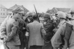 SS-Untersturmführer Heinrich Wicker (mostly hidden behind aide) speaking with US General Henning Linden, Dachau Concentration Camp, Germany, 29 Apr 1945; also present were journalist Paul Levy (with helmet, looking down), Dr. Victor Maurer (facing away)