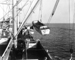 Crewmen of the USS Elmore hoisting LCVPs as part of disembarking United States Army troops of the 19th Infantry Regiment, 3rd Battalion for the beaches at Leyte, Philippines, 20 Oct 1944.