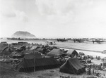 A Douglas R4D (C-47) transport plane (center) loading wounded Marines on Iwo Jima