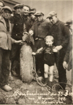 Civilians posing with a bomb recently disarmed by a US Army bomb disposal unit, La Louvière, Belgium, May 1945