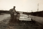 William Woolfolk with a highway sign near Aachen, Germany, Apr 1945