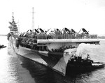 Essex-class Aircraft carrier USS Hornet gliding into Berth F-9 on the northwest corner of Ford Island, Pearl Harbor, Oahu, Hawaii, 4 Mar 1944. Note SB2C Helldivers on the flight deck and Measure 33, Design 3a paint.