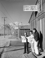 Roy Takeno, editor of the Manzanar Free Press (left), with Yuichi Hirata and Nabuo Samamura in front of the newspaper office at the Manzanar Relocation Center for deported Japanese-Americans, 1943.