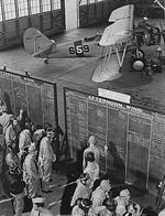 US Navy aviation cadets check flight boards for last minute instructions, Naval Air Training Center, Naval Air Station Corpus Christi, Texas, United States, Nov 1942; note N3N-3 Canary aircraft