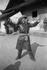 Chinese war correspondent mocking surrendering Japanese soldiers, Changde, Hunan Province, China, 25 Dec 1943, photo 1 of 2; note Arisaka Type 38 rifle, signed flag, helmet, and Type 91 or Type 95 gas mask