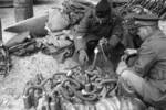 Chinese and foreign officers inspecting captured Japanese Type 91 or Type 95 gas masks (with tubes) and Type 90 oxygen mask (without tube), Changde, Hunan Province, China, 25 Dec 1943