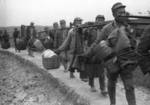 Chinese laborers using carrying poles to transport unidentified rifles and bedding for Chinese soldiers and photographic equipment for foreign correspondents, Changde, Hunan Province, China, 25 Dec 1943