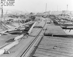 View from the demolished pier looking toward shore and more flattened buildings following a munitions explosion at Port Chicago, California, United States, 17 Jul 1944. 18 Jul 1944 photo.