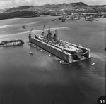 USS Wisconsin in floating drydock ABSD-1 in Apra Harbor, Guam, 5 Apr 1952. Note Oregon, the ex-battleship converted to ammunition barge, in the distance off Wisconsin’s bow.