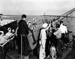 Men aboard the destroyer USS Shaw drilling on the No. 3 5”/38 caliber gun, Jul 1942 probably off San Diego. Note the open pedestal mount and the sailors at left holding the 5-inch practice shells.