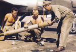 Armorers handling an HVAR air-to-surface rocket, circa 1945, location unknown. Note the rocket fuse on the ground at left.