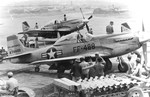 HVAR air-to-surface rockets being mounted on P-51D Mustangs of the 39th Fighter Interceptor Squadron at the Chinhae Air Base (now Jinhae), South Korea, May 51. Note the large rocket trailer in the foreground.