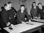 Staged photograph taken during the court martial trial of US Navy Captain Charles McVay. Former Japanese submarine I-58 commander Mochitsura Hashimoto is seen using a chart, Washington DC, 13 Dec 1945.