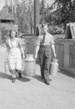 RAF Leading Aircraftman James Shorter and Norwegian civilian Sigrid Skau carrying milk churns at an RAF station of 88 Group near Oslo, Norway, 1945
