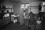 Two WAAF cooks at RAF St Eval preparing rations for Whitley aircraft crews of No. 502 Squadron RAF Coastal Command, Padstow, Cornwall, England, United Kingdom, 1940s; note box of oranges, an imported rarity