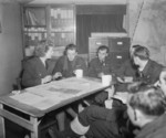WAAF intelligence officer Section Officer P. Duncalfe questioning No. 49 Squadron RAF Lancaster bomber pilot Warrant Officer H. Blunt (to her left) and his crew upon their return to Fiskerton, Lincolnshire, England, United Kingdom after a raid on Berlin, Germany, 22 Nov 1943; this crew would be killed five days later during another mission to Berlin