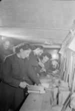 A corporal instructor assisting two WAAF members during their joinery class of the RAF Educational and Vocational Training Scheme, United Kingdom, date unknown