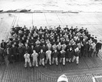 Photo of the 130 survivors of destroyer USS Borie on the flight deck of USS Card following a memorial service for the 27 shipmates lost in the sinking 2 Nov 1943 (photo about 8 Nov 1943).