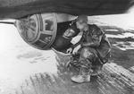 Radio Operator TSgt Robert Myllykoski of the 306th Bomb Group trying to squeeze into the ball turret of B-17 Fortress “Unbearable II” at RAF Thurleigh, Bedfordshire, England, mid-1943. Looking on is SSgt John Jessup.