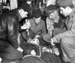 Medical personnel of the 306th Bomb Group at RAF Thurleigh, Bedfordshire, England tending to a wounded airman, 1944-45.