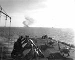 Burning escort carrier USS Ommaney Bay as seen from sister ship USS Steamer Bay, 4 Jan 1945, Sulu Sea, Philippines. Ommaney Bay had been struck by a Japanese special attack aircraft and was later scuttled.