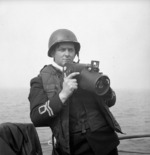 Lieutenant Gilbert A. Milne of the Royal Canadian Naval Volunteer Reserve with a Fairchild K-20 aerial camera, 2 Jun 1944.