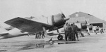 A6M3 Model 32 Zero fighter resting at an airfield with the crew meeting nearby, date unknown